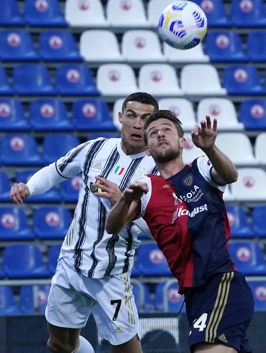 Penyerang Juventus, Cristiano Ronaldo dan bek Cagliari, Daniele Rugani berebut bola dalam laga pekan ke-27 Liga Italia di Sardegna Arena, Minggu (14/3/2021). Ronaldo mencetak hat-trick untuk membawa Juventus meraih kemenangan atas Cagliari 3-0. (Alessandro Tocco/LaPresse via AP)