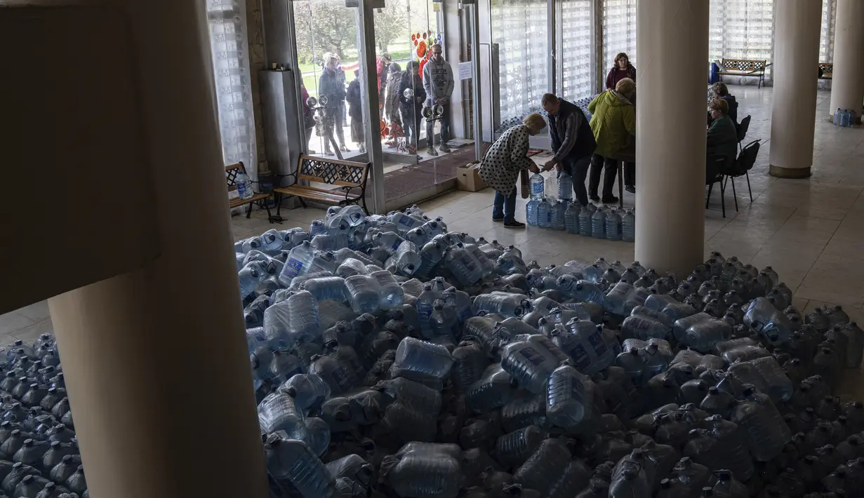 <p>Penduduk setempat menerima air minum di pusat distribusi di Toretsk, Ukraina timur, pada 25 April 2022. Penduduk Toretsk tidak memiliki akses air selama lebih dari dua bulan karena perang Rusia Ukraina. (AP Photo/Evgeniy Maloletka)</p>