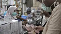 Pedagang melayani pembeli masker di toko alat kesehatan di Pasar Pramuka, Jakarta, Selasa (4/2/2020). Isu merebaknya wabah virus corona di Indonesia membuat penjualan masker di Pasar Pramuka meningkat pesat meski dalam sepekan harga melonjak tajam. (merdeka.com/Iqbal Nugroho)