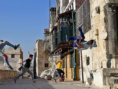 Pemuda Suriah berlatih parkour di Aleppo, Suriah utara, (7/4). Setelah pemerintah Suriah mengambil alih kendali penuh Aleppo dari pasukan pemberontak Desember 2016, beberapa pemuda kini menyalurkan hobinya, yaitu parkour.  (AFP Photo/George Ourfalian)