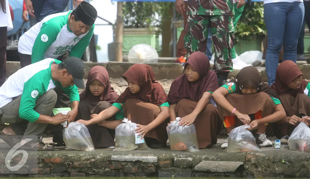 Para murid SDN Pamarican 2 Serang melakukan sebar sejuta ikan di danau Tasikardi, Serang Baten, Sabtu (28/5). untuk menebarkan kesadaran akan kualitas kebersihan lingkungan, sosial dan pendidikan di Indonesia. (Liputan6.com/Angga Yuniar)