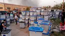 Sejumlah petugas menyelamatkan kotak suara saat kebakaran gudang surat suara terbesar Irak di Baghdad, Minggu (10/6). Penyebab kebakaran di gudang penyimpanan itu juga masih belum jelas. (AP/Karim Kadim)