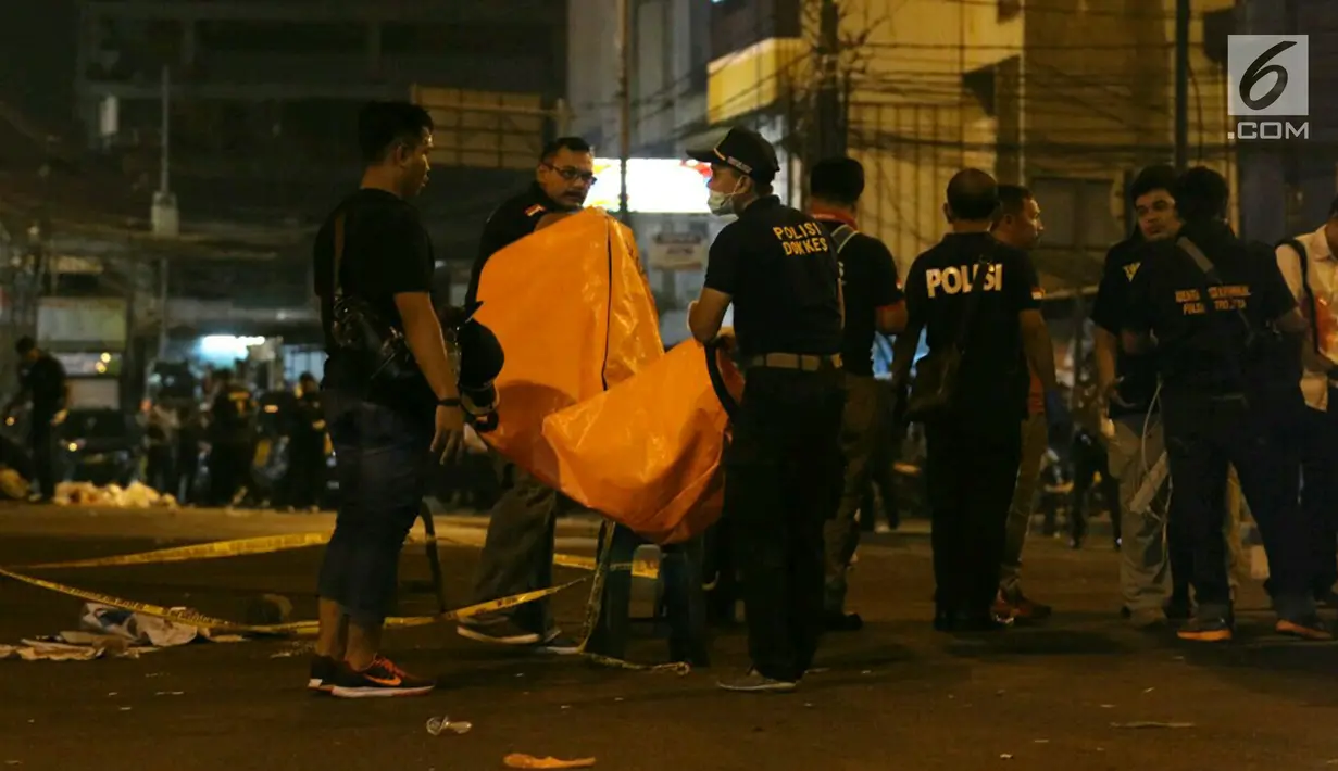 Polisi dan Puslabfor mengevakuasi potongan jenazah ketika  olah TKP ledakan di Terminal Kampung Melayu, Rabu (24/5). Jarak warga semakin menjauh di radius sekitar 150 meter lebih dari TKP. (Liputan6.com/Angga Yuniar)