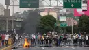 Demonstran dari oposisi memblokir sebuah jalan di Caracas, Venezuela (24/4). Protes anti pemerintah ini digelar untuk memblokir jalanan dalam upaya menghentikan aktivitas di Venezuela. (AP Photo/Fernando Llano)