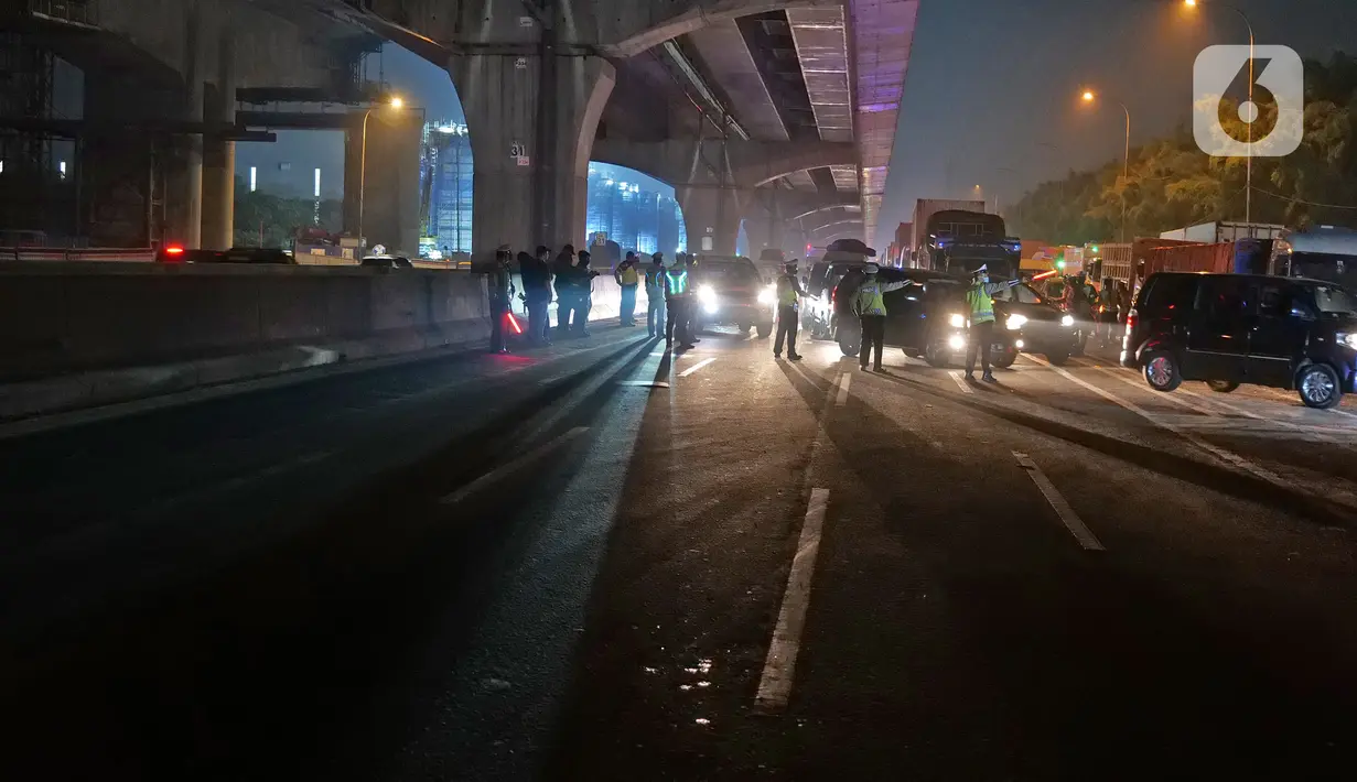 Polisi menghalau kendaraan berpenumpang di tol Jakarta-Cikampek untuk keluar ke Gerbang tol Cikarang Barat, Kab. Bekasi, Jumat (24/4/2020). Akses transportasi mobil pribadi dan bus angkutan penumpang dari tol Jakarta Cikampek menuju Karawang ditutup mulai Jumat (24/4). (Liputan6.com/Herman Zakharia)