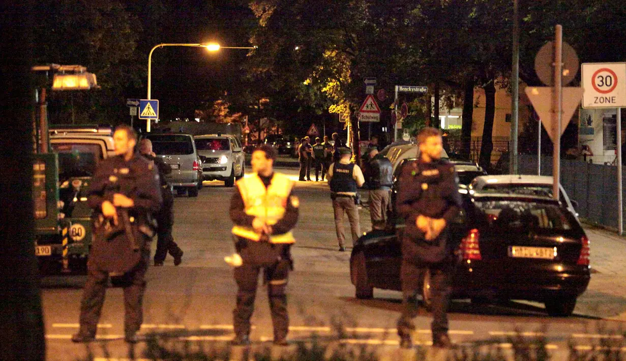 Petugas kepolisian berdiri di sebuah jalan kecil menyusul penembakan di pusat perbelanjaan Olympia di Munich, Jerman (22/7). Kepolisian menyatakan penembakan dilakukan oleh seorang remaja blasteran Jerman-Iran berusia 18 tahun.  (REUTERS/Christian Mang)