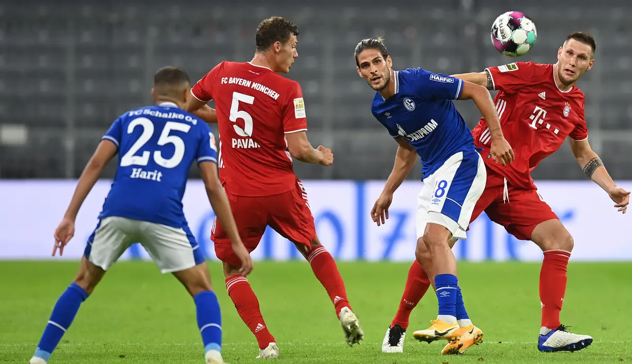 Bek Bayern Munchen, Benjamin Pavard, berebut bola dengan pemain Schalke pada laga Liga Jerman di Allianz Arena, Sabtu (19/9/2020) dini hari WIB. Bayern Munchen menang 8-0 atas Schalke. (AFP/Christof Stache)
