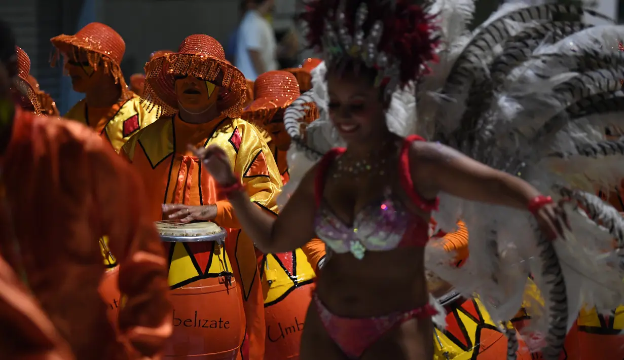 Penabuh genderang dan penari, bagian dari anggota Comparsa ambil bagian dalam parade karnaval Llamadas di Montevideo, Kamis (7/2). Para penari dengan berbagai kostum menarik meriahkan parade tersebut di jalanan Montevideo. (PABLO PORCIUNCULA/AFP)
