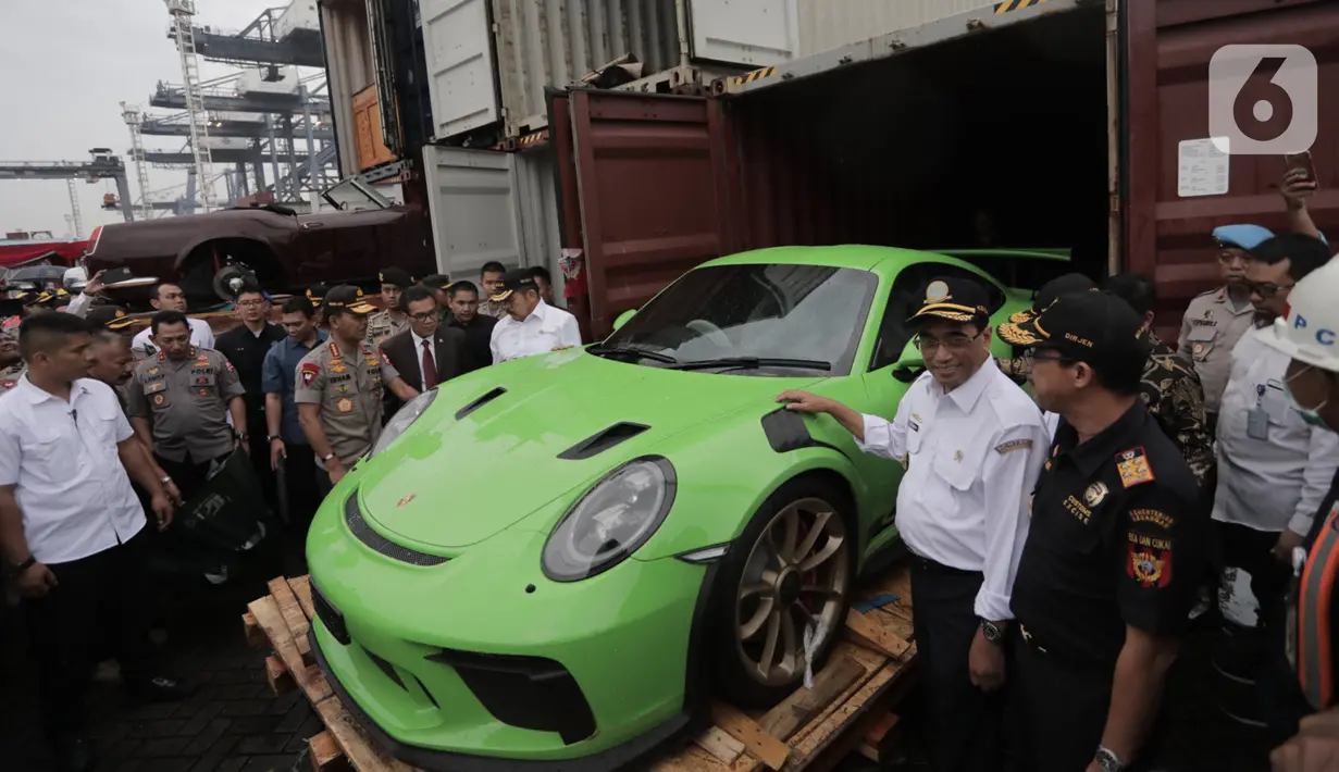 Menhub Budi Karya Sumadi (kedua kanan) mengecek barang bukti kasus penyelundupan mobil dan motor mewah di Terminal Petikemas Koja, Jakarta, Selasa (17/12/2019). Bea Cukai menggagalkan penyelundupan 19 unit mobil mewah, 35 unit motor mewah, rangka, dan mesin. (merdeka.com/Iqbal Nugroho)