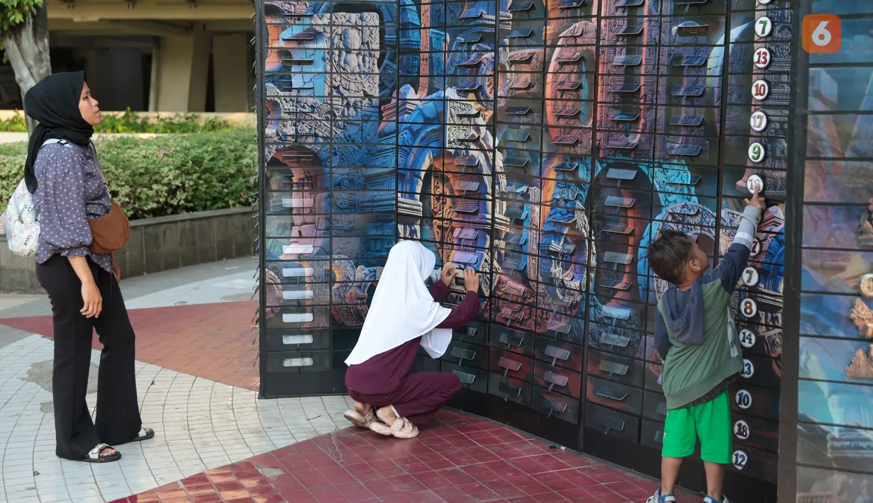Pengunjung mengamati karya dalam pameran seni rupa kontemporer luar ruang Jakarta Provoke! di Taman Menteng, Jakarta Pusat, Jumat (17/7/2026). Pameran gratis yang berlangsung hingga 26 Juli 2026 ini menghadirkan 25 karya dari 25 seniman dan kolektif tentang dinamika kehidupan Jakarta. (KLY/Budy Santoso)