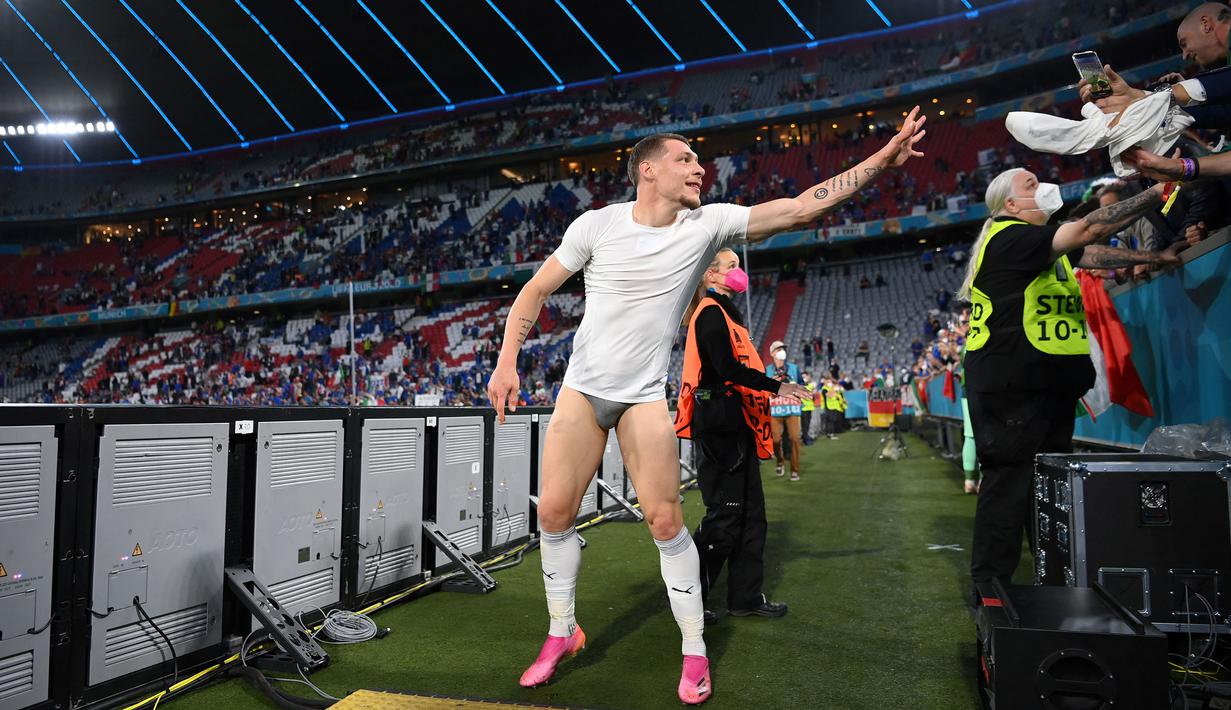Penyerang Italia, Andrea Belotti melemparkan celana pendeknya kepada para suporter saat dirinya merayakan kemenangan setelah pertandingan Perempatfinal EURO 2020 antara Belgia dan Italia yang berlangsung di Allianz Arena, Munich pada 2 Juli 2021.
(AFP/Pool/Matthias Hangst)