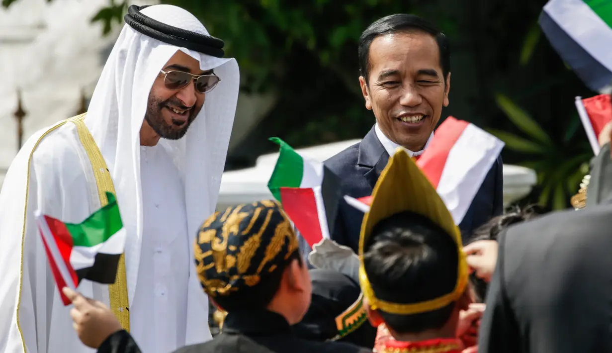 Presiden Jokowi bersama Putra Mahkota Abu Dhabi, Sheikh Mohamed Bin Zayed Al Nahyan menyapa sejumlah anak berpakaian daerah saat kunjungan kenegaraan di Istana Bogor, Kamis (24/7/2019). Keduanya menggelar pertemuan bilateral guna membahas sejumlah kerja sama. (Willy Kurniawan/Pool Photo via AP)