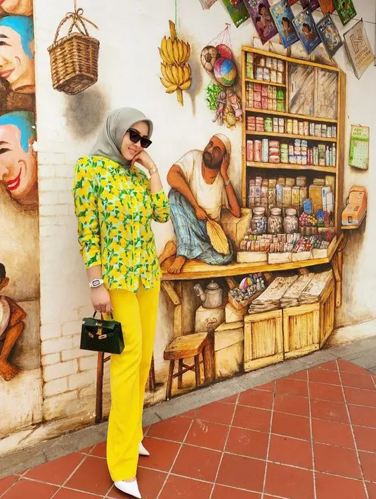 Syahrini membagikan potret dirinya menjalani puasa Ramadan di Singapura. Seperti potret ini, dia tampil modis dengan kemeja kuning dari Alice + Olivia. Kemeja tersebut ditaksir seharga Rp5,4 juta. (Instagram/princessyahrini).