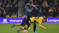 Gelandang Arsenal, Martin Odegaard berebut bola dengan pemain Wolverhampton Wanderers, Daniel Podence  selama pertandingan lanjutan Liga Inggris di stadion Molineux di Wolverhampton, Inggris, Jumat (11/2/2022). Arsenal menang tipis atas Wolverhampton Wande 1-0. (AP Photo/Rui Vieira)