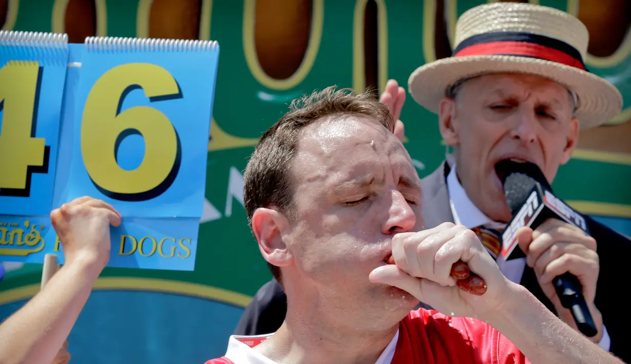 Ekspresi Joey Chestnut saat menyantap dua hot dog dalam Kontes Makan Internasional Nathan, di New York, AS (4/7). Joey Chestnut hanya kalah sekali dari Matt Stonie pada 2015. (AP Photo/Bebeto Matthews)