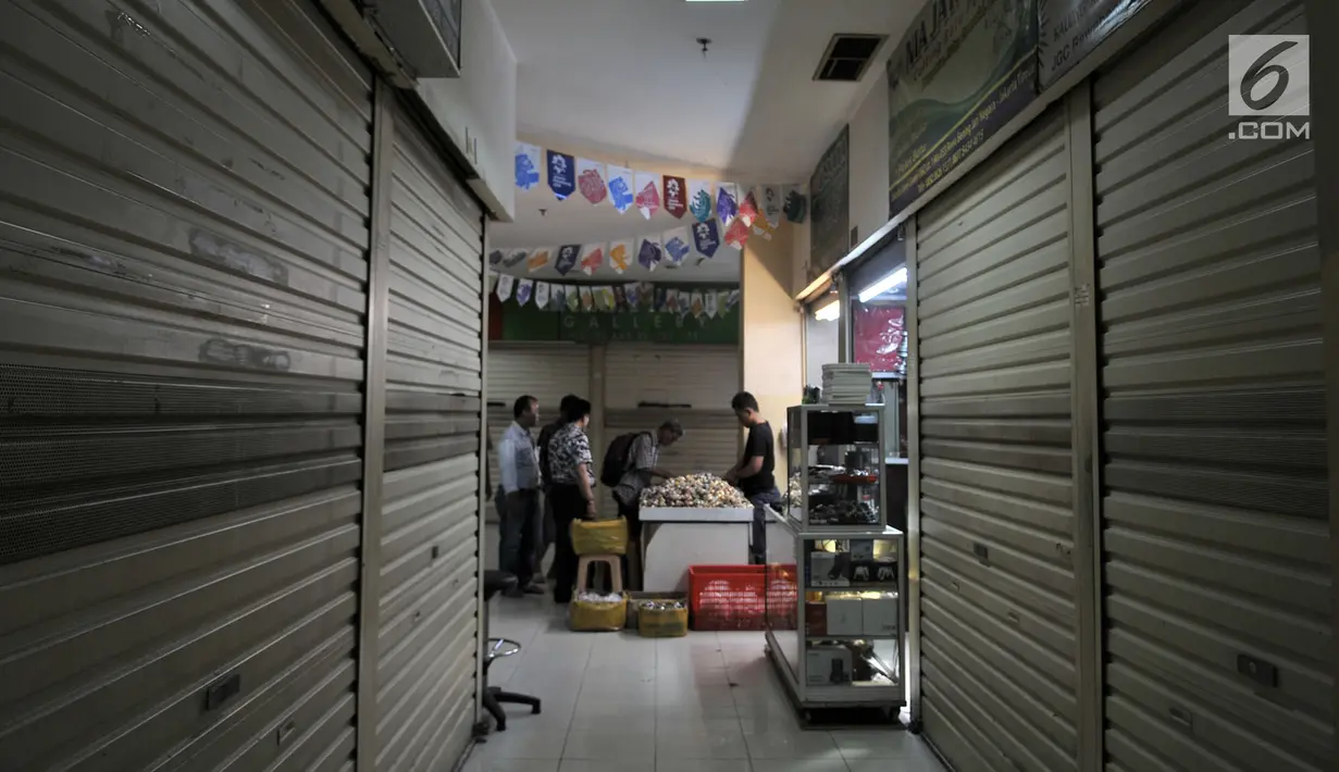 Pengunjung melihat koleksi batu akik di salah satu kios yang masih bertahan di Pasar Rawa Bening, Jakarta, Senin (10/9). Pedagang mengaku omzet dari penjualan saat ini menurun hingga 50 persen tidak seramai 4 tahun silam. (Merdeka.com/Iqbal S. Nugroho)