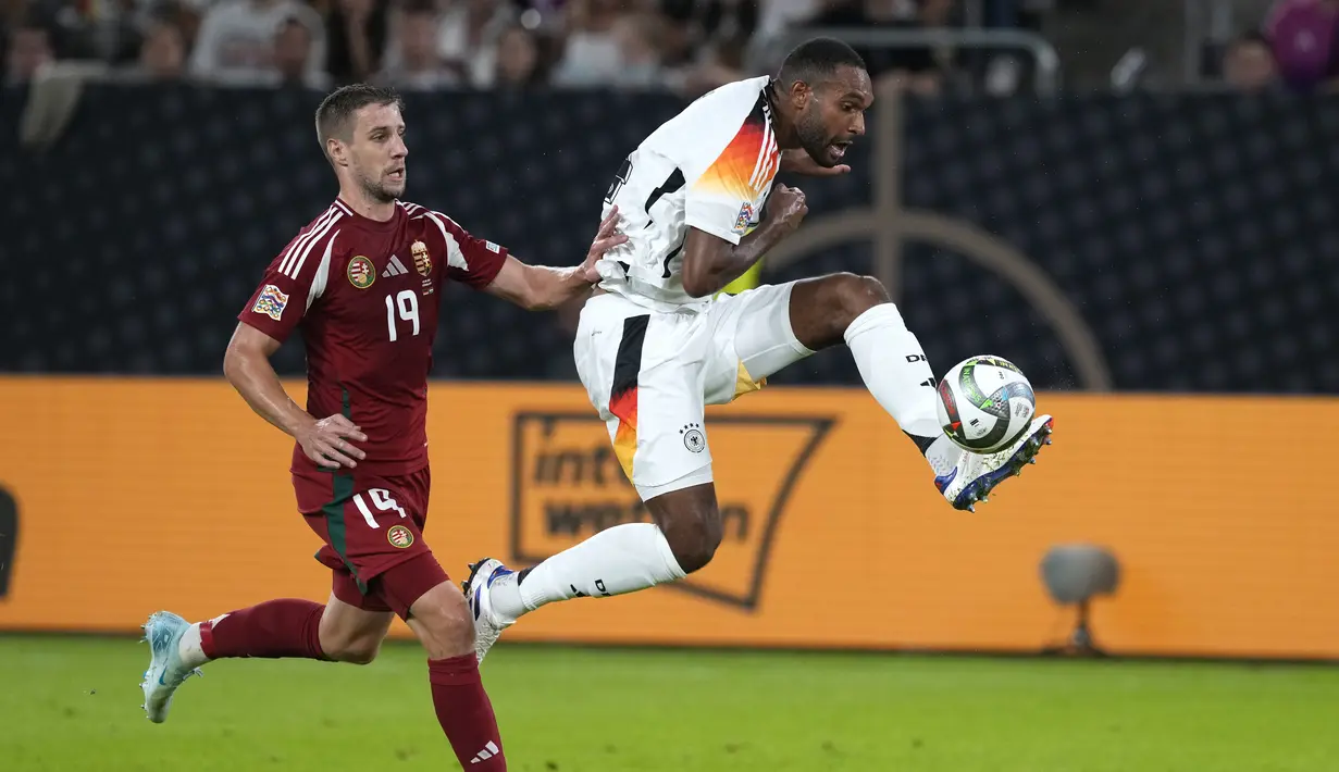 Bek Jerman Jonathan Tah menendang bola saat penyerang Hungaria Barnabas Varga mencoba menghentikannya pada ertandingan pertama grup C UEFA Nations League 2024,, Minggu (8/9/2024) awal hari WIB. (AP Photo/Michael Probst)