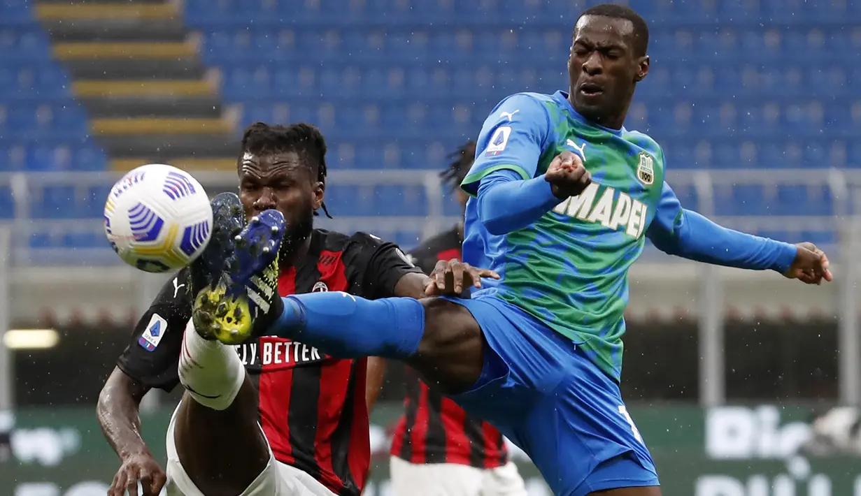 Gelandang AC Milan, Franck Kessie (kiri) berebut bola dengan gelandang Sassuolo, Pedro Obiang dalam laga lanjutan Liga Italia 2020/2021 pekan ke-32 di San Siro Stadium, Milan, Rabu (21/4/2021). AC Milan kalah 1-2 dari Sassuolo. (AP/Antonio Calanni)
