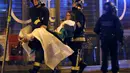 Korban yang terluka mendapat pertolongan dari petugas usai aksi penembakan dan bom bunuh diri yang dilakukan teroris di Paris, Perancis, Jumat (13/11/2015). Dikabarkan ada 140 orang tewas dalam aksi teroris tersebut. (Reuters)