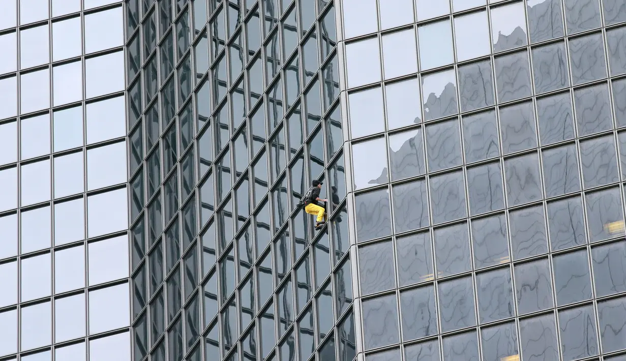 Pemanjat gedung, Alain Robert beraksi memanjat gedung tanpa alat bantu di pusat bisnis La Defense, Paris, Prancis, Senin (21/3/2016). Pria yang dijuluki 'Spiderman' ini telah memanjat lebih dari 70 gedung tertinggi di dunia. (Jacques DEMARTHON/AFP)