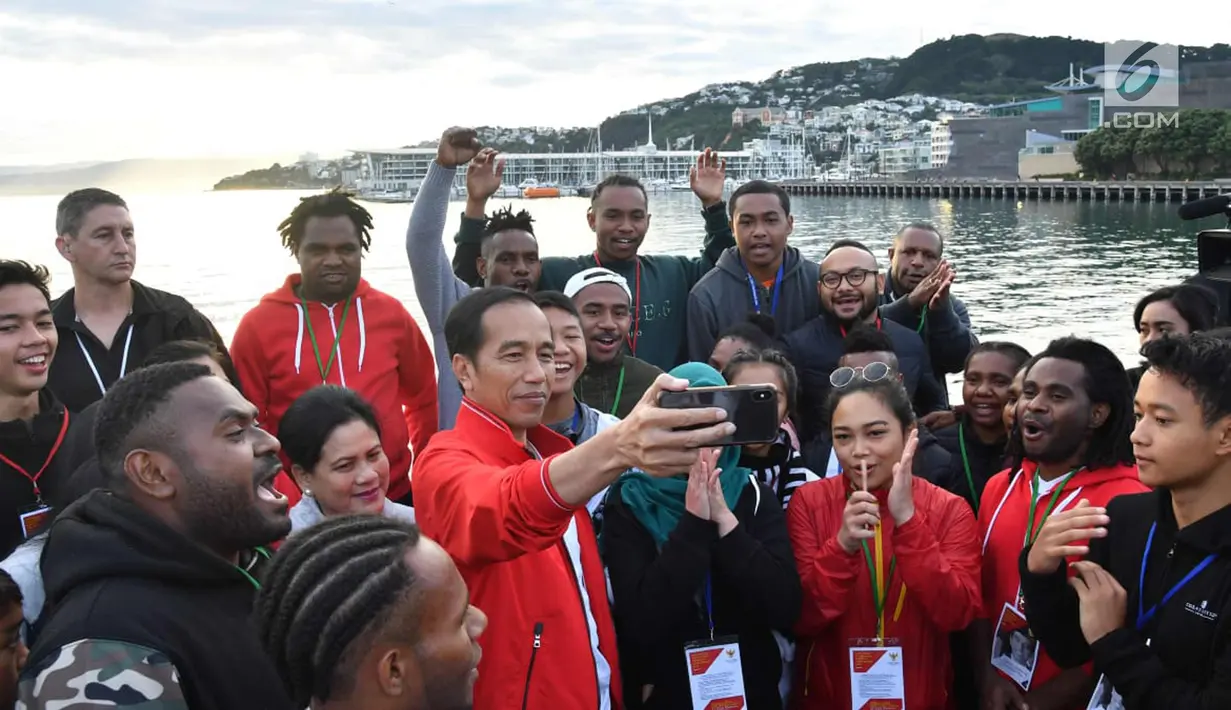 Presiden Joko Widodo bersama Ibu Negara Iriana Joko Widodo berselfie dengan 29 pelajar dan mahasiswa Indonesia di Waterfront Wellington, Selandia Baru (19/3).  (Liputan6.com/Pool/Biro Pers Setpres)