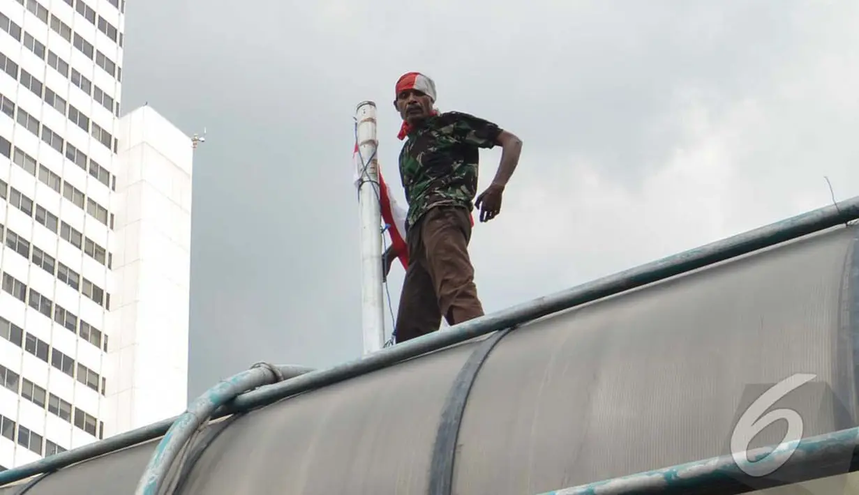 Seorang pria nekat melakukan aksi di atap jembatan penyeberangan orang (JPO) di Jl MH Thamrin, Jakarta Pusat (Liputan6.com/Johan Tallo)