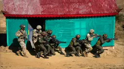 Tentara Angkatan Darat AS dari Brigade ke-2 Divisi Lintas Udara ke-11 dengan tentara India melakukan operasi pura-pura untuk mengusir orang-orang bersenjata dari sebuah rumah saat latihan bersama Indo-US atau Yudh Abhyas di Auli, Uttarakhand, India, 29 November 2022. Militer India dan Amerika Serikat menggelar latihan tempur dengan medan pegunungan yang disengketakan dengan China. (AP Photo/Manish Swarup)