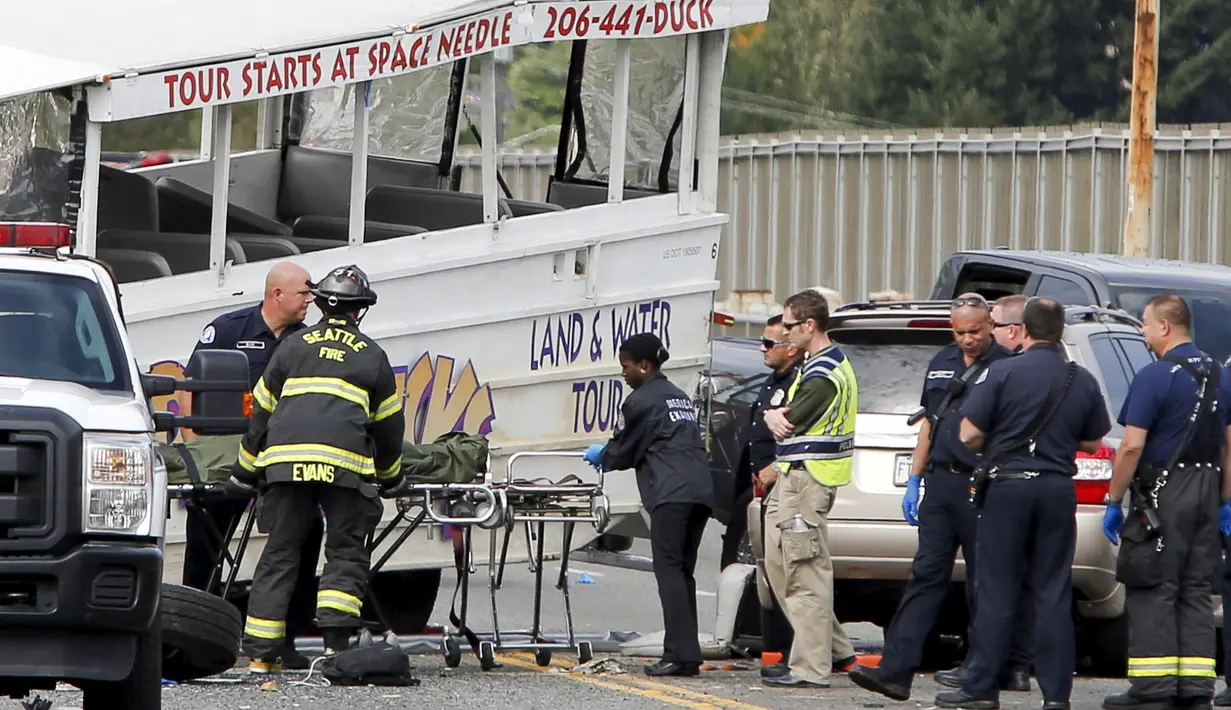 Petugas saat mengevakusi korban kecelakaan antara bus carter mahasiswa dengan kendaraan wisata amfibi di sebuah jembatan di Seattle, AS, Kamis (25/9). Kecelakaan itu menewaskan satu WNI bernama Privando Eduardus Putradanto. (REUTERS/Jason Redmond)