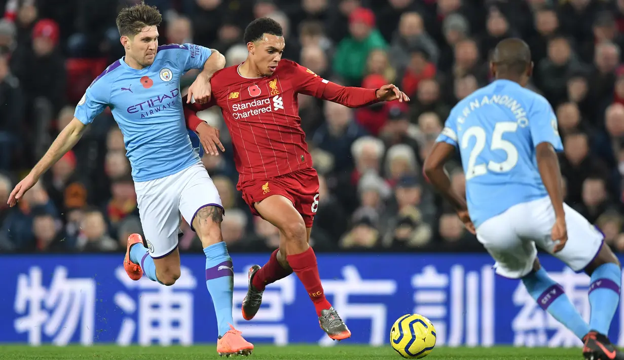Bek Liverpool, Trent Alexander-Arnold berebut bola dengan bek Manchester City, John Stones dalam pertandingan pekan ke-12 Liga Inggris 2019-2020 di Anfield, Minggu (10/11/2019). Liverpool menghabisi Man City dengan skor cukup telak 3-1. (Paul ELLIS / AFP)