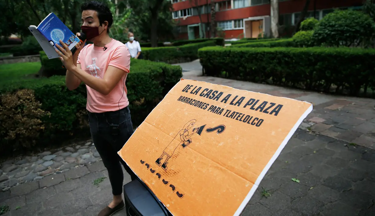 Percibald Garcia menggunakan mikrofon untuk membacakan cerita anak-anak di tengah-tengah kompleks perumahan Tlatelolco di Mexico City pada 18 Juli 2020. Lockdown akibat pandemi corona membuat arsitek muda berusia 27 tahun itu memutuskan untuk berbagi cerita menghibur anak-anak. (AP/Marco Ugarte)