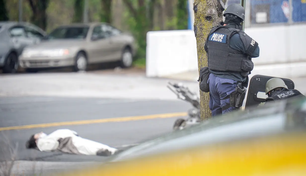 Seorang pria dirobohkan dengan tembakan senjata oleh petugas di luar stasiun televisi Fox 45 di Baltimore, Amerika Serikat (AS), Kamis (28/4). Pria berkostum panda itu mengancam akan meledakkan stasiun televisi Fox 45. (REUTERS/Bryan Woolston)