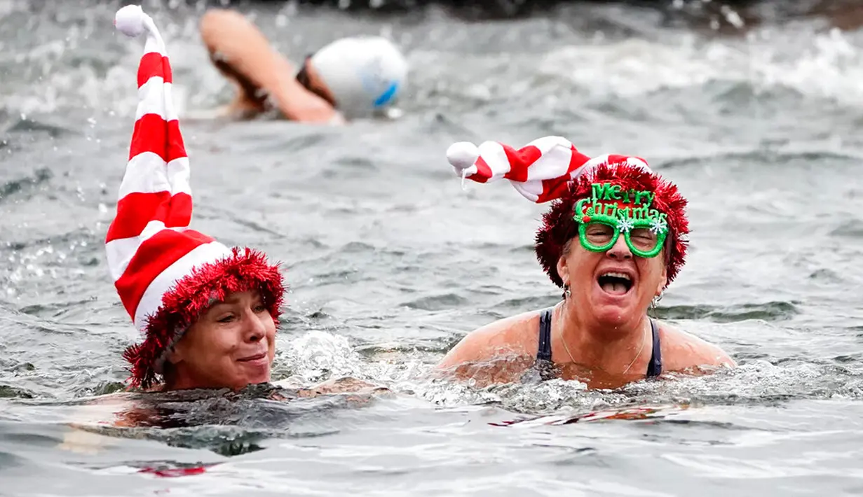 Anggota Serpentine Swimming Club mengikuti perlombaan Peter Pan Cup yang diadakan setiap Hari Natal di Serpentine, London, Inggris, Minggu (25/12/2022). (Aaron Chown/PA via AP)