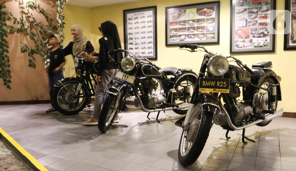 Pengunjung melihat motor antik yang dipamerkan di Museum Angkut, Kota Batu, Jawa Timur, Kamis (15/12/2022). Museum Angkut memiliki lebih dari 300 koleksi jenis angkutan tradisional hingga modern. (Liputan6.com/Herman Zakharia)