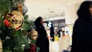 Pengunjung melintasi pohon natal di toko Selfridges, London, Senin (6/8). Kebijakan membuka gerai ornamen natal jauh hari sebelum natal tiba ternyata untuk memfasilitasi para turis dari luar negeri yang sedang berkunjung ke London. (AP/Robert Stevens)