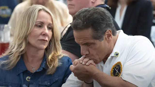 Gubernur New York Andrew Cuomo mencium tangan seorang perempuan.