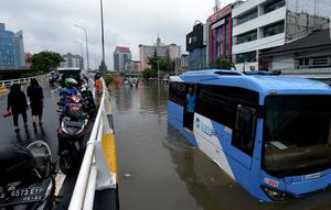 Bus transjakarta terendam banjir di Jalan Raya Daan Mogot, Jakarta, Rabu (1/1/2020). Hujan yang turun saat malam pergantian tahun baru 2019-2020 menyebabkan sejumlah titik jalan terputus di kawasan Grogol terendam banjir. (merdeka.com/Imam Buhori)