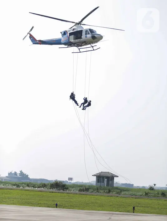 Anggota Polairud turun dari helikopter saat simulasi penangkapan atau pengungkapan transaksi narkoba saat perayaan HUT ke-69 Polairud di Mako Polairud, Pondok Cabe, Tangerang, Rabu (4/12/2019). Dalam simulasi tersebut Polairud mengerahkan helikopter hingga anjing K9. (Liputan6.com/Faizal Fanani)