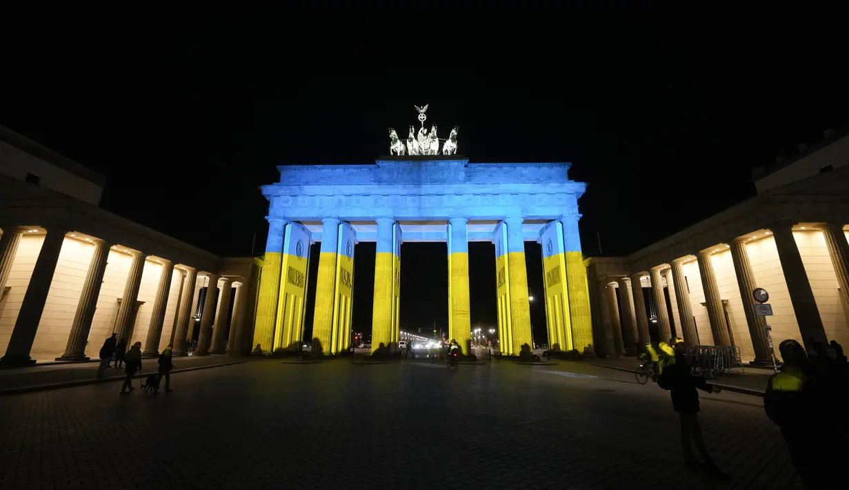 Gerbang Brandenburg diterangi dengan warna bendera Ukraina di Berlin, Jerman, Rabu (23/2/2022). Salah satu bangunan ikonik itu diterangi warna bendera nasional Ukraina, biru dan kuning untuk menunjukkan solidaritas selama ketegangan negera itu dengan Rusia. (AP Photo/Markus Schreiber)