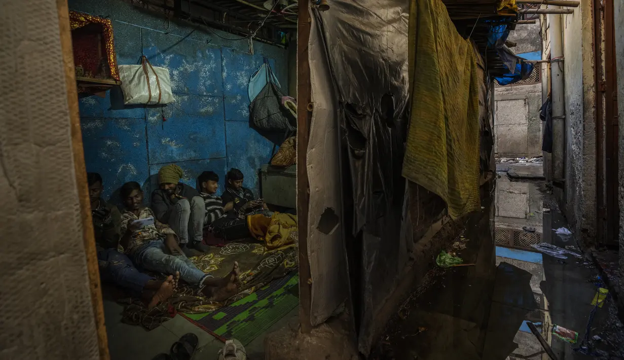 Air selokan mengalir di samping gubuk yang dibangun di kompleks tempat penampungan bobrok untuk para tunawisma di New Delhi, Jumat, 30 Desember 2022. Meskipun tempat penampungan malam kota adalah tempat perlindungan bagi banyak orang yang seharusnya tidur di dekat bundaran dan underpass yang sibuk lalu lintas, kebanyakan orang di sana hidup dalam kondisi yang keras. (AP Photo/Altaf Qadri)