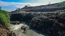 Warga memanfaatkan aliran Kali Pesanggrahan yang menyempit untuk mendulang benda-benda logam di kawasan Pasir Putih, Depok, Jawa Barat, Senin (27/4/2026), setelah longsoran sampah dari Tempat Pembuangan Akhir (TPA) Cipayung menutup sebagian badan sungai. (merdeka.com/Arie Basuki)