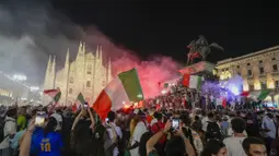 Pendukung Italia merayakan kemenangan di depan Katedral Duomo, Milan pada Senin (12/07/2021), setelah Italia berhasil mengalahkan Inggris pada Final Euro 2020 yang berlangsung di Stadion Wembley, London. Italia mengalahkan Inggris 3-2 dalam adu penalti setelah bermain imbang 1-1. (AP/Luca Bruno)
