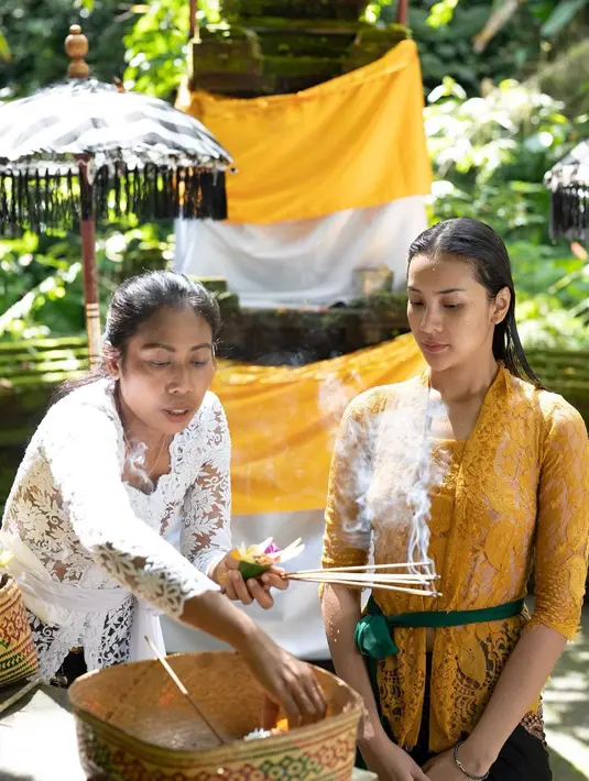 Aktris Anya Geraldine saat menjalani tradisi Melukat di Bali. Anya yampil anggun bak wanita Bali dengan kebaya berwarna mustard dan kain batik, serta kelopak bunga di telinganya. (Instagram/anyageraldine)