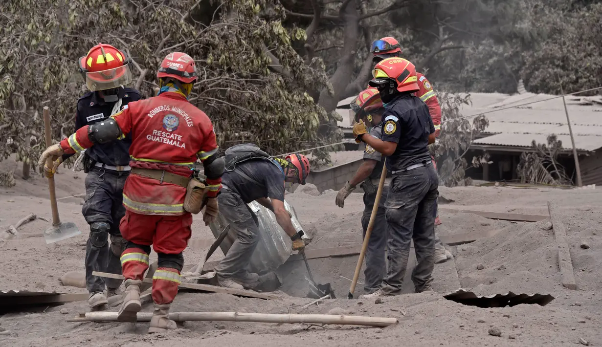 Tim penyelamat membongkar atap rumah warga untuk mencari korban dari letusan gunung Feugo di desa San Miguel Los Lotes, Guatemala (5/6). (AFP/Johan Ordonez)