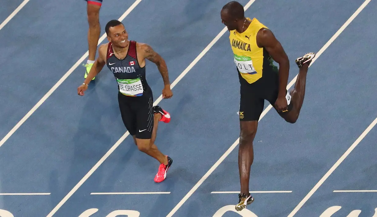 Usain Bolt dan Andre de Grasse mengobrol saat berada di dekat garis finish pada semifinal lari 200 meter pria di Rio de Janeiro, Brasil (17/8). Usain Bolt meraih medali emas kedua di lari 200 meter pria. (REUTERS/Fabrizio Bensch)
