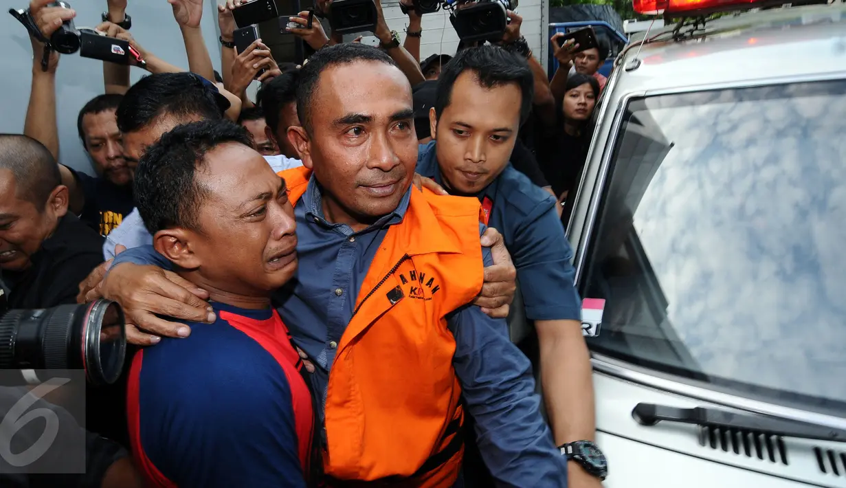 Bupati Buton nonaktif, Samsu Umar Abdul Samiun dipeluk kerabatnya usai menjalani pemeriksaan di Gedung KPK, Jakarta, Kamis (26/1). Samsu Umar tersangka dugaan suap Ketua Mahkamah Konstitusi Akil Mochtar, Oktober 2016. (Liputan6.com/Helmi Fithriansyah)