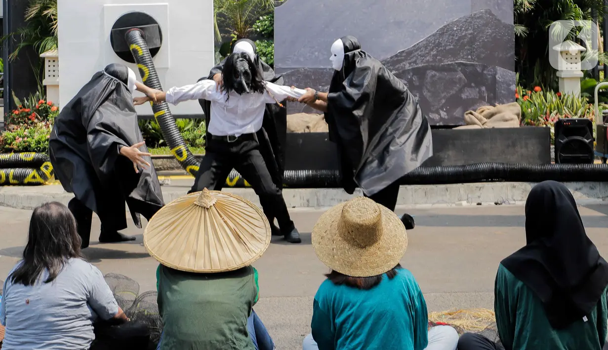 Aktivis lingkungan yang tergabung dalam Koalisi Demokrasi Energi menggelar aksi teatrikal saat unjuk rasa dalam rangka menyambut Hari Listrik Nasional di depan kantor pusat PLN,Jakarta, Kamis (26/10/2023). (Liputan6.com/Herman Zakharia)