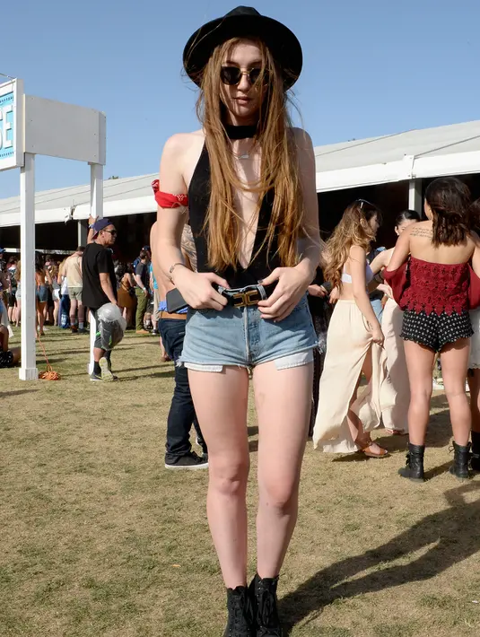 Seorang wanita berpose mengenakan topi dan kacamata hitam saat menghadiri hari pertama Coachella Valley Music and Arts Festival 2016 di Empire Polo Club, California (15/4). Festival ini masuk sebagai festival Musik Terbesar di Dunia. (AFP/Matt Cowan)