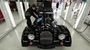 Pekerja memoles mobil yang baru selesai diproduksi di tempat pemeriksaan di pabriknya di Malvern, Birmingham, Inggris (13/8/2019). Morgan Motor Company didirikan pada tahun 1909 oleh HFS Morga. (AFP Photo/Oli Scarff)