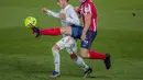 Penyerang Atletico Madrid, Luis Suarez berebut bola dengan gelandang Real Madrid, Lucas Vazquez pada pertandingan La Liga Spanyol di stadion Alfredo Di Stefano, Spanyol, Minggu (13/12/2020). Madrid menang atas Atletico 2-0. (AP Photo/Bernat Armangue)