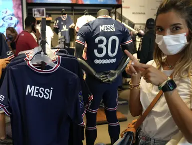 Suporter Paris Saint-Germain memberi isyarat dengan jersey bertuliskan nama Lionel Messi di toko resmi PSG, di Paris, Rabu (11/8/2021). Penjualan jersey PSG dengan nama Messi dan nomor punggung 30 laris manis, bahkan rela antre panjang. (AP Photo/Francois Mori)